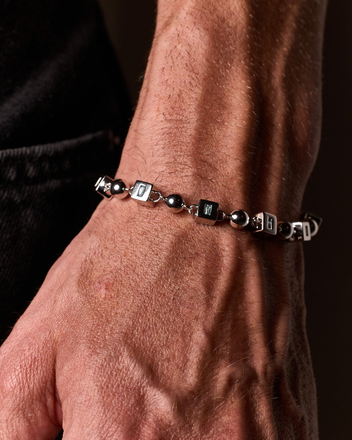 Model wearing the Topaz Bracelet handcrafted from solid 925 sterling silver with natural blue topaz stones one.